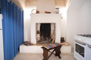 a room with a fireplace with a table in front of it at Masseria Giangrande - Rooms and Apartment in Polignano a Mare