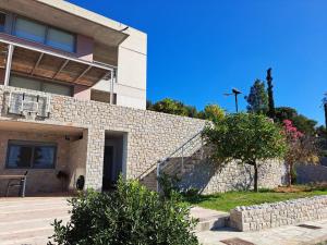 a house with a stone wall next to a building at Nafplio, hill with an amazing view in Nafplio