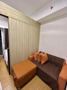 uma sala de estar com um sofá castanho e uma cadeira em Grace residences staycation em Manila