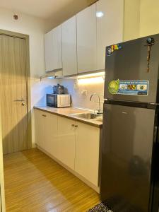 uma pequena cozinha com um lavatório e um frigorífico em Grace residences staycation em Manila