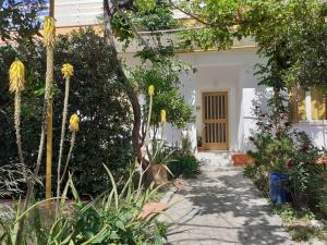 a white house with a pathway leading to a door at Kampos Rooms in Palaiochora