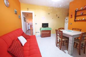 a living room with a red couch and a table at GD Case Vacanza - Fronte Mare - in Lido Marini