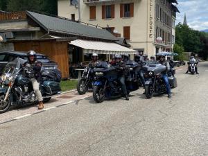 grupa ludzi jeżdżących motocyklami po ulicy w obiekcie Hôtel Restaurant de la poste w mieście Saint-Colomban-des-Villards