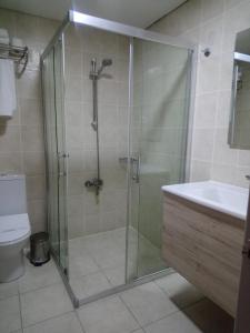 a bathroom with a shower with a sink and a toilet at Grand Faik Hotel in Cesme