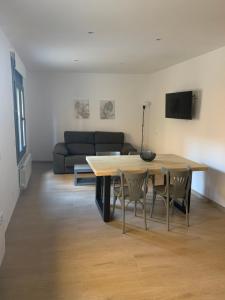 a living room with a table and chairs and a couch at CAL JAN - La Muralla in Bellver de Cerdanya