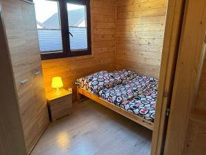 Cette petite chambre comprend un lit dans une cabane en bois. dans l'établissement Ośrodek Wczasowy Amelia, à Jarosławiec