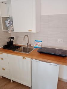 a kitchen counter with a sink and a laptop on it at Alghero d'Estate in Alghero