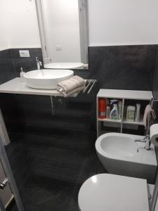 a bathroom with a sink and a toilet and a mirror at Alghero d'Estate in Alghero