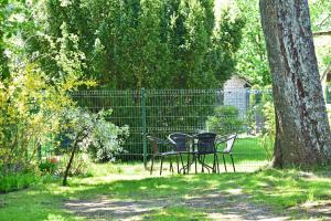 dos sillas y una mesa junto a un árbol en SMILTIS, en Palanga