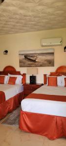 a hotel room with two beds and a painting of a boat at Eliwes Villa in Treasure Beach