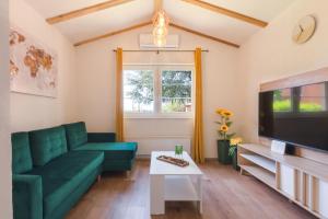 a living room with a green couch and a tv at Casa Laurales in Veli Turini