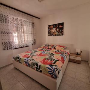 a bedroom with a bed with a colorful comforter at Apartman Dora with sea view and terrace in Umag