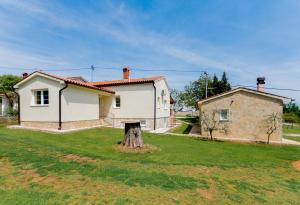 a house with a tree stump in the yard at Casa Laurales in Veli Turini