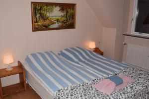 een blauw en wit gestreept bed in een slaapkamer bij Nygammelsø Bed & Breakfast in Stege
