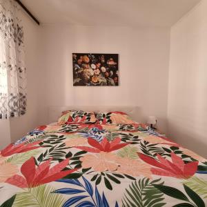 a bed with a colorful comforter in a bedroom at Apartman Dora with sea view and terrace in Umag