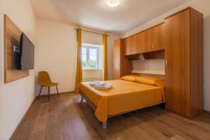 a small bedroom with a bed and a chair at Casa Laurales in Veli Turini +34 photos