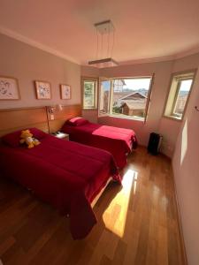 Duas camas num quarto com lençóis vermelhos em Quatro Estações Hospeda - Le Verbier 14 - Conforto com vista para as montanhas em Campos do Jordão