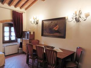 una sala da pranzo con tavolo e sedie in legno di Relais Santa Margherita a Capolona