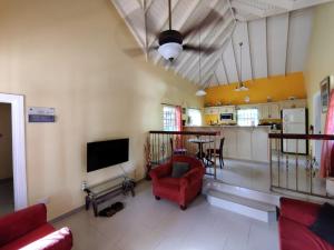 a living room with a red chair and a table at BenCastle Villa in Gros Islet