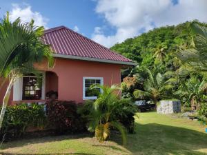 a pink house with palm trees in front of it at BenCastle Villa in Gros Islet