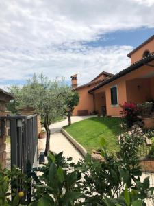 ein Haus mit einem Garten und einem Hof mit einem Haus in der Unterkunft Il giardino delle rose in Spello