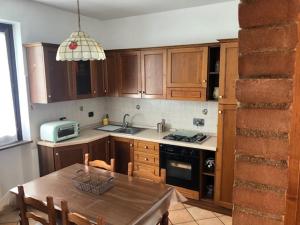 a kitchen with wooden cabinets and a table and a microwave at Il giardino delle rose in Spello
