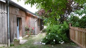 un patio trasero con una valla de madera y algunas flores en Bienvenue au gîte de Claret, en Casseneuil