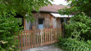 a wooden fence in front of a small shed at Bienvenue au gîte de Claret in Casseneuil