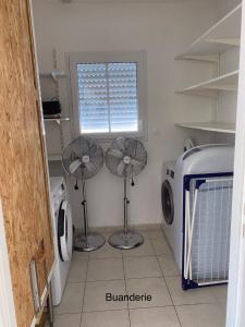 uma lavandaria com 2 ventoinhas e uma máquina de lavar roupa em Entre plage et marais em Bourcefranc