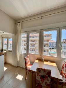una sala da pranzo con finestre, tavolo e sedie di Mint Apartment a Tivat