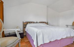 ein Schlafzimmer mit einem Bett und einem Stuhl in der Unterkunft Gorgeous Home In Aramon With Kitchen in Aramon
