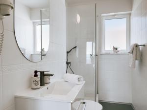 a white bathroom with a sink and a mirror at Apartments Goro in Podstrana