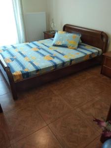 a bed with a blue comforter and a pillow on it at THEO house in Kyllini Zakynthos in Kyllini