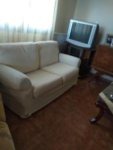 un soggiorno con divano bianco e TV di THEO house in Kyllini Zakynthos a Kyllini