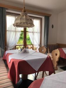 a room with a table with a red and white table cloth at Gästehaus Schwarzlofer in Reit im Winkl