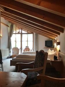 a bedroom with a bed and a couch and a chair at Gästehaus Schwarzlofer in Reit im Winkl