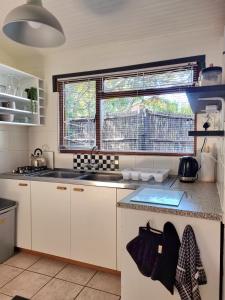 a kitchen with white cabinets and a sink and a window at 81 Kingfisher in Lake Marina