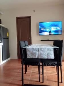 a dining room table with two chairs and a television on the wall at Dreamy 2BR condo, with a golf course view in Cebu City