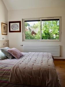 - une chambre avec un grand lit et une grande fenêtre dans l'établissement Les Héliades, à Le Touquet-Paris-Plage