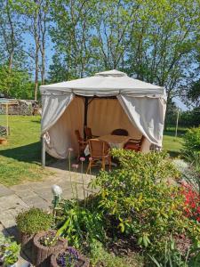 a gazebo with chairs and a table in a garden at Ferienwohnung Am Stadtrand Garz Rügen in Garz-Rügen