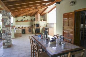 eine Küche mit einem Holztisch und Stühlen in einem Zimmer in der Unterkunft Villa D'Anna in Cefalú