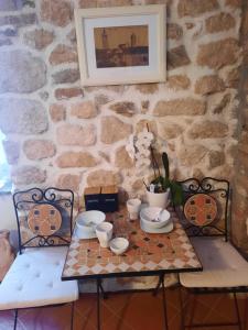 uma mesa com duas cadeiras e uma parede de pedra em Room Ivana em Rab