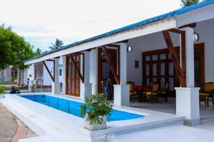 eine Villa mit einem Pool und einem Haus in der Unterkunft Ceylonta Beach Resort in Hambantota