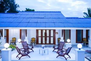 un grupo de sillas y mesas frente a una casa en Ceylonta Beach Resort, en Hambantota