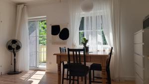 a dining room table and chairs in a room with windows at Glanz und Gloria Velden! Wörthersee in 5 min zu Fuß erreichbar! in Velden am Wörthersee