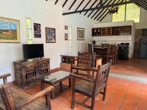 a living room with chairs and a television and a table at Cabaña milenio 1 in Moniquirá
