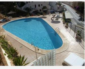 a large blue swimming pool on a patio at Frente a Tabarca in Santa Pola