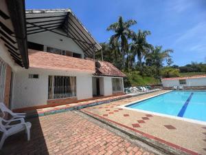 a villa with a swimming pool in front of a house at Cabaña milenio 1 in Moniquirá