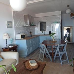 a living room with a table and a kitchen at Frente a Tabarca in Santa Pola