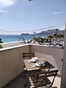 een tafel op een balkon met uitzicht op het strand bij FAMILY HOUSE Letojanni Taormina in Letojanni